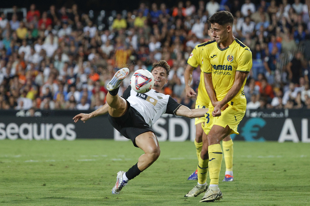 El centrocampista del Valencia Sergi Canos (i) intenta rematar ante Sergi Cardona, del Villarreal, durante el encuentro de la cuarta jornada de LaLiga entre el Valencia CF y el Villarreal, este sábado en el estadio de Mestalla, Valencia. EFE/ Manuel Bruque